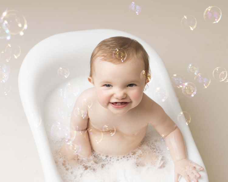 Playing with bubbles in the bath after a cake smash and bath splash session at Wirral Merseyside  photo studio
