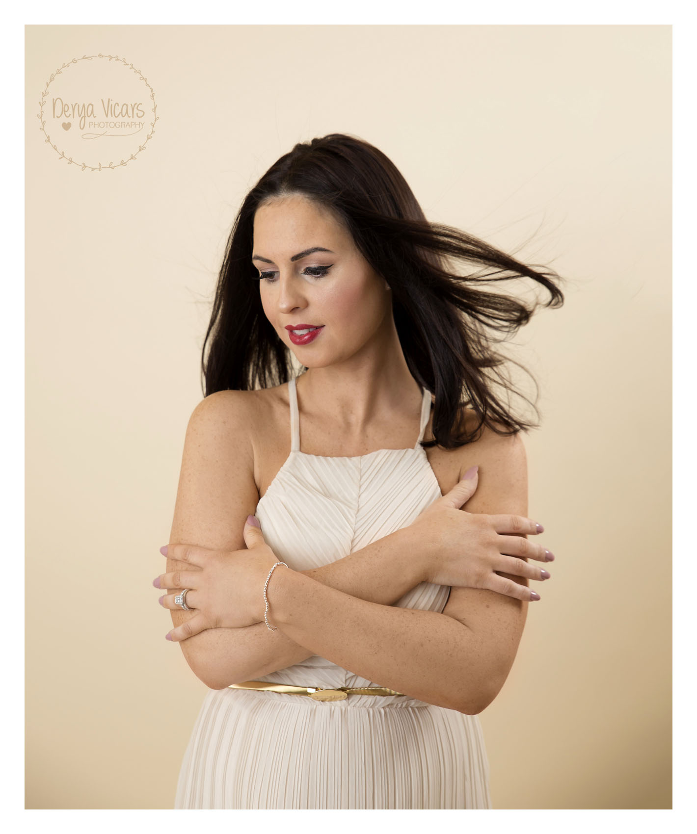 Hoylake Maternity Session with Dark Hair Blowing to the Right, Hands Crossing Chest