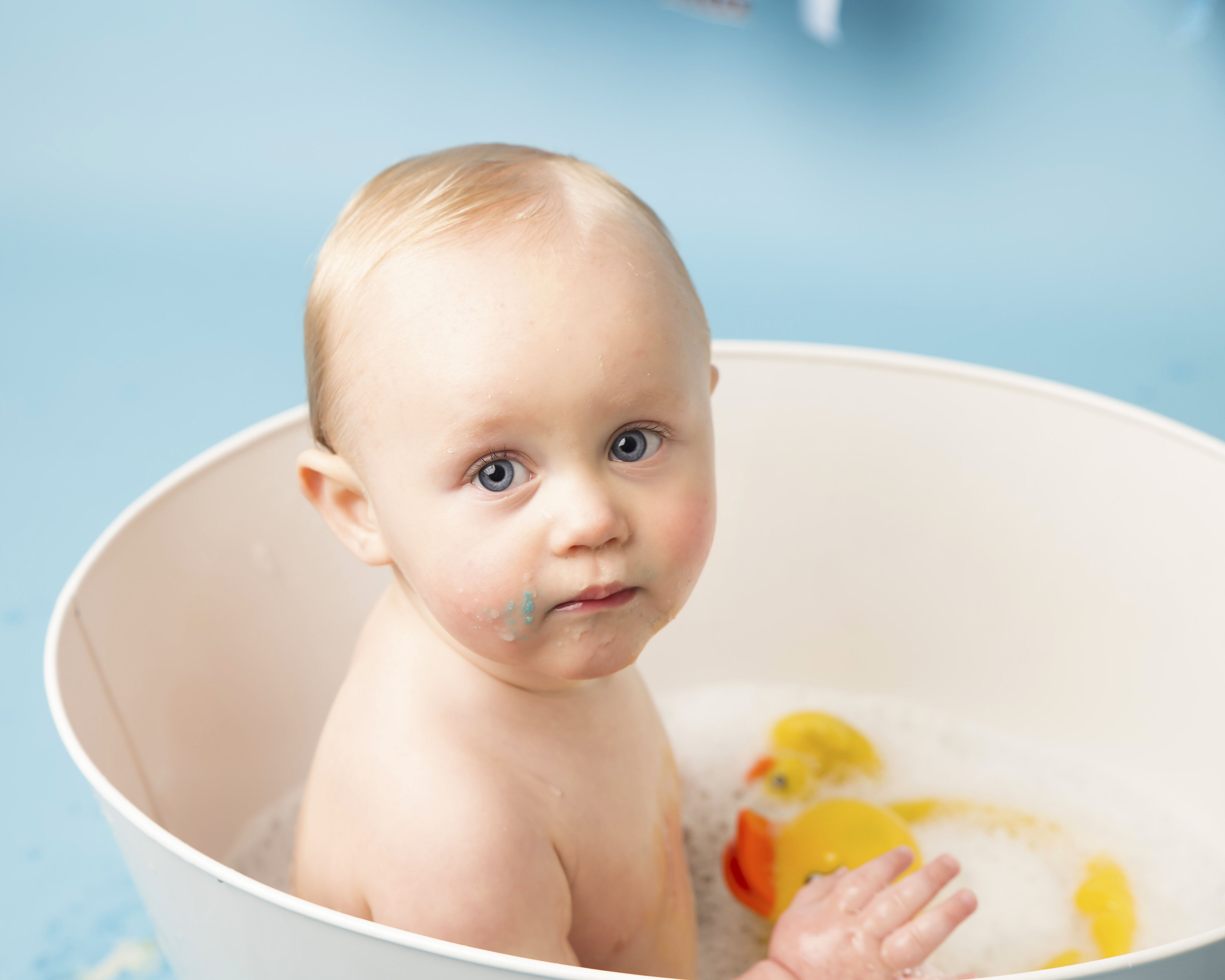 Baby Boy in a white tin bath with a yellow rubber duck - Wirral based Photographer